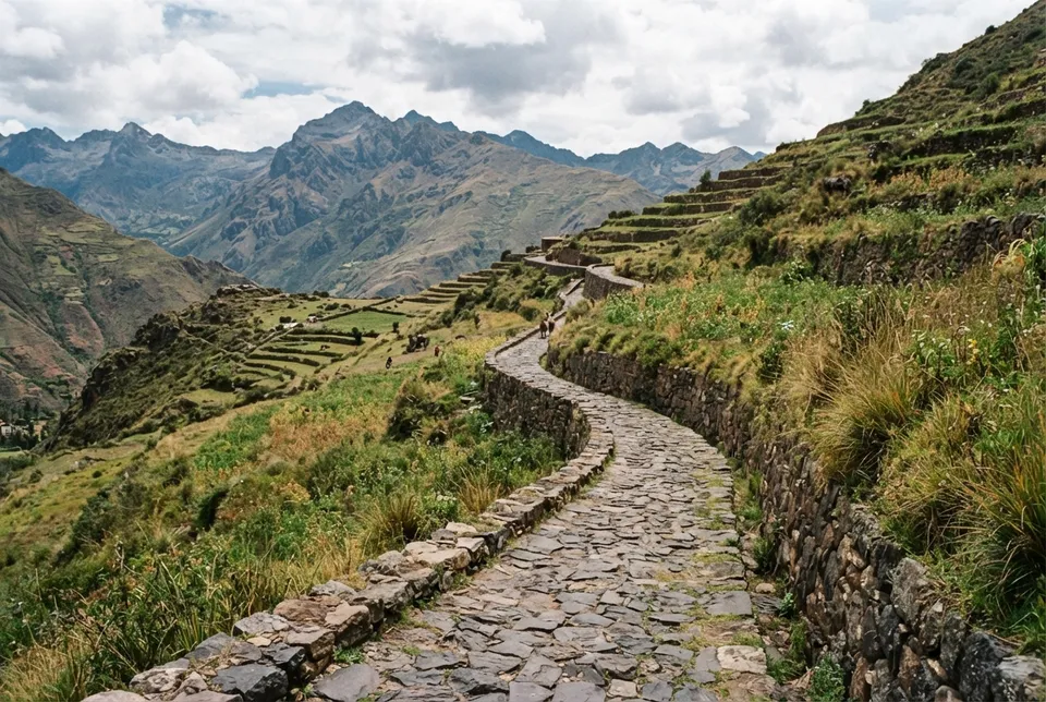 Sección conservada del Qhapaq Ñan con pavimento de piedra y terrazas laterales en los Andes