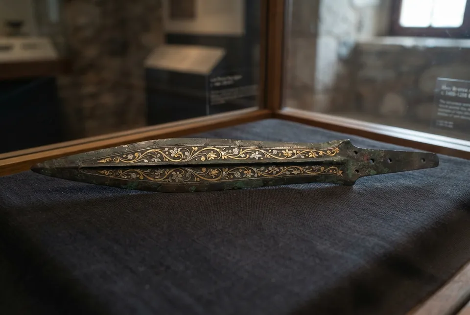 Objeto micénico de bronce con tallos estilizados y hojas, reflejando un alto nivel artesanal y simbólico